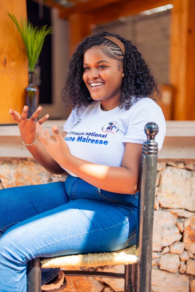 Une participante sourit, assise, en t-shirt du concours