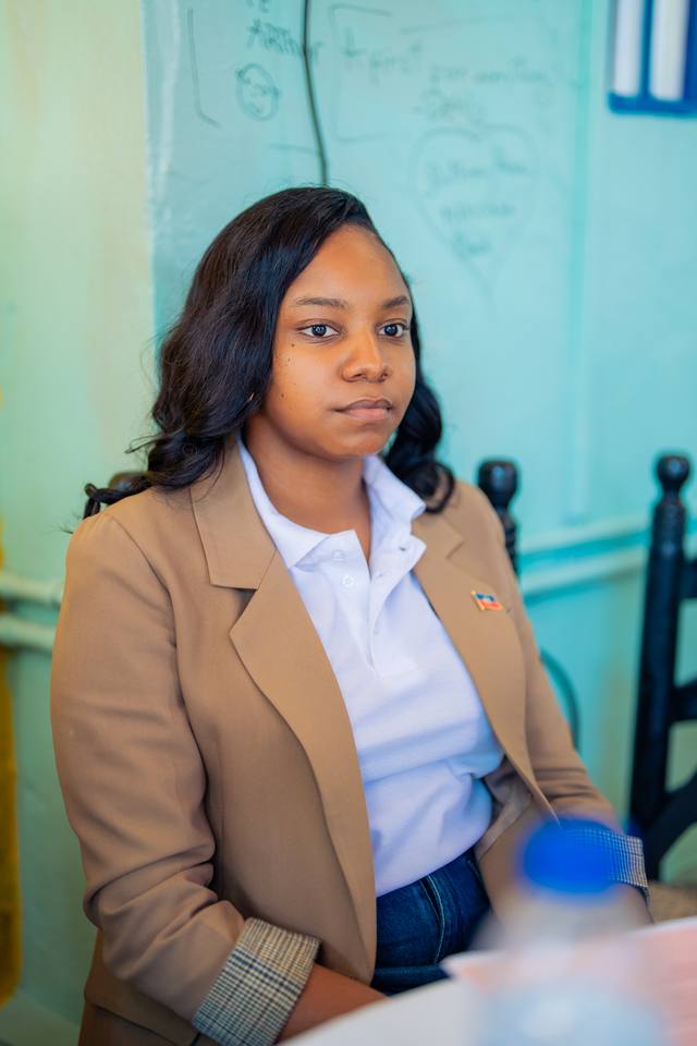Une participante en blazer, assise à une table